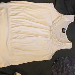 Sleeveless white top, neck lined in pearl